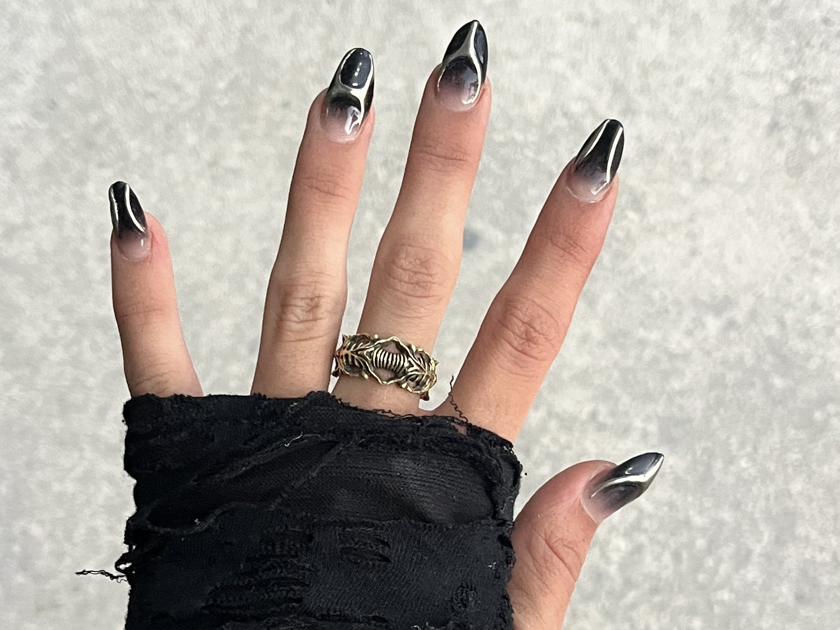 Actual BIOORGA brass ring worn with a black fingerless glove and black and silver nail art.